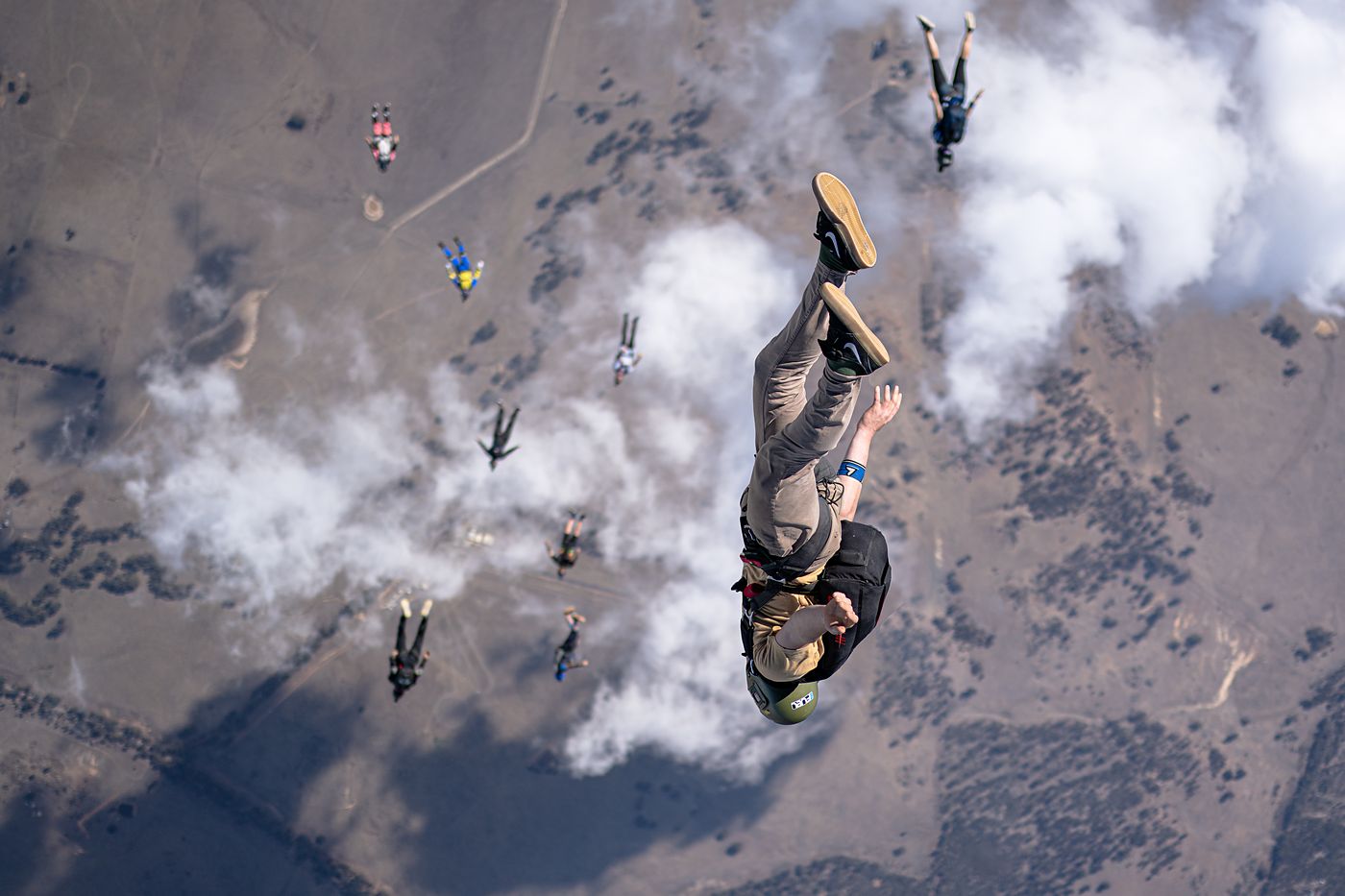 A skydiver dropping through a break in the cloud