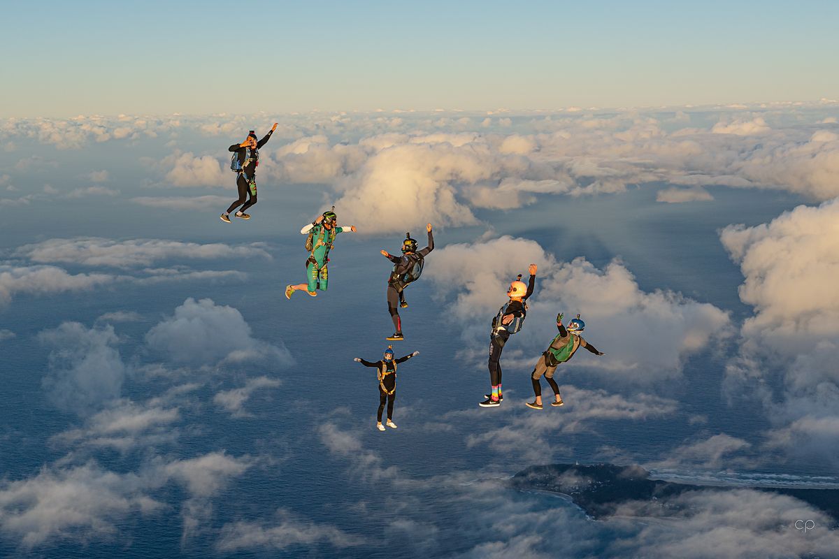A group flying belly-down over the cloud tops