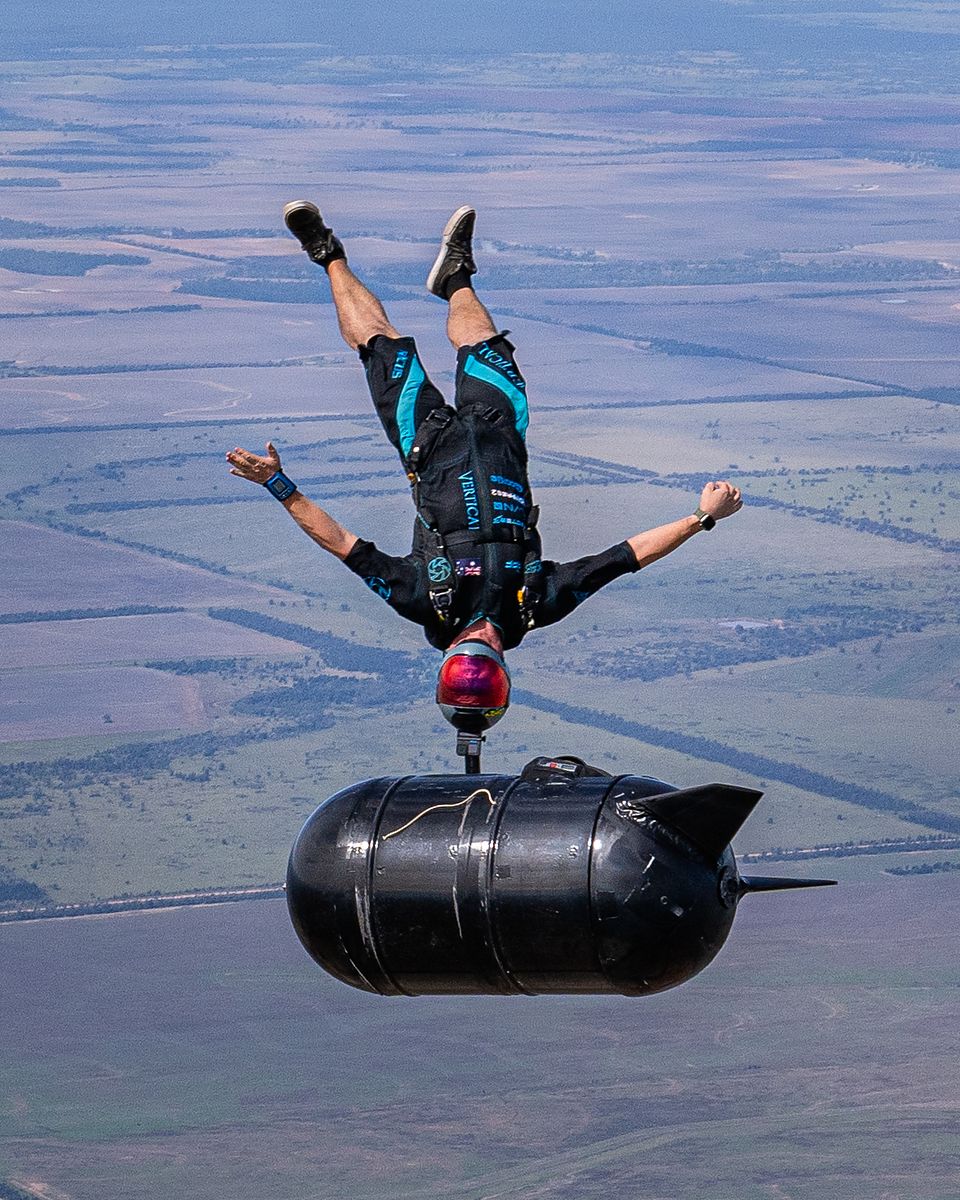A flyer tracking beside a large black object in freefall