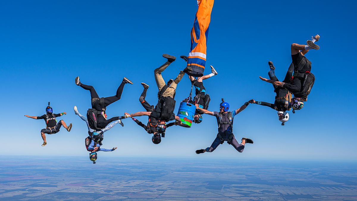 A head-down group flying above farmland