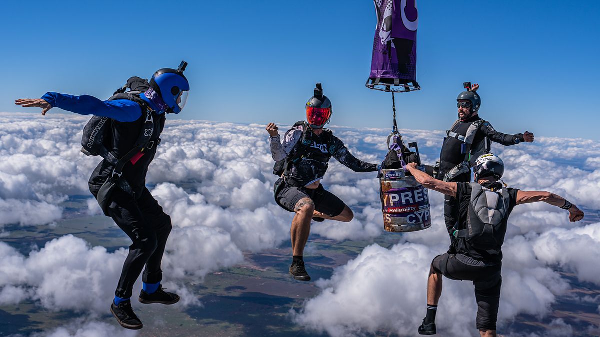 Flyers gripped around an object above a cloud layer