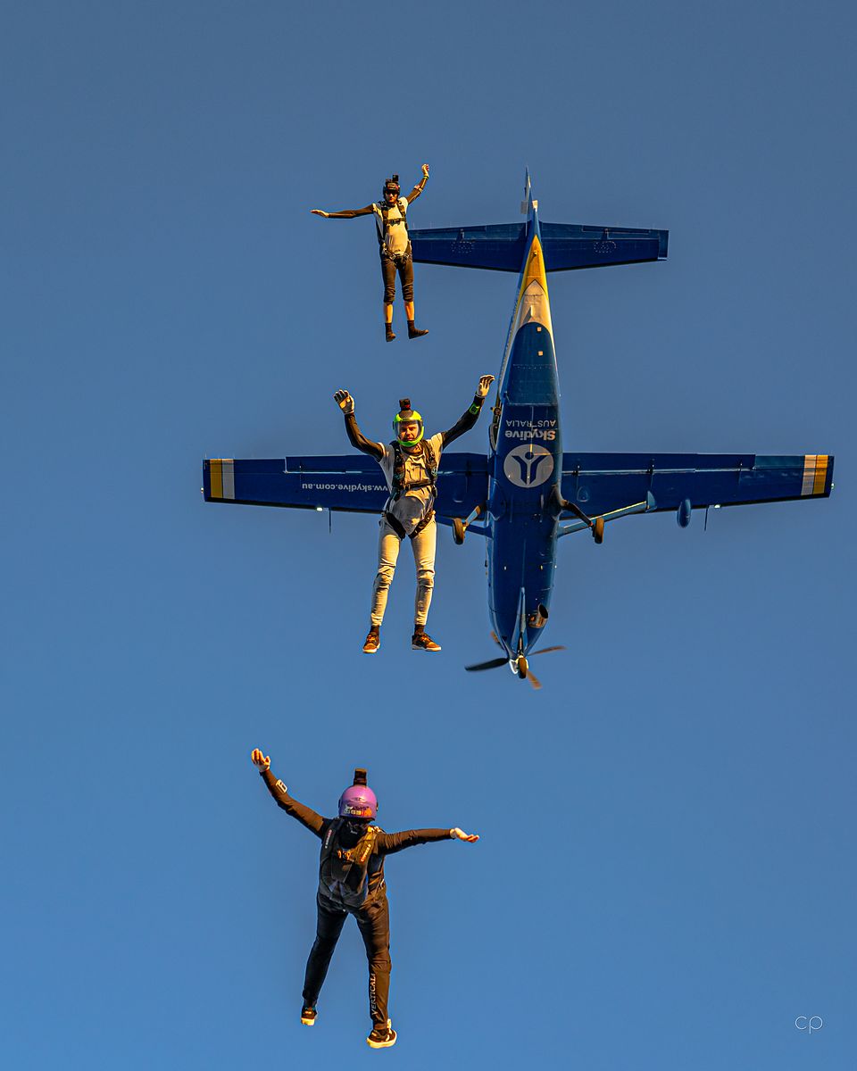 Skydivers flying formation around the aircraft after exit