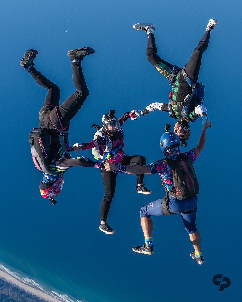A head-down round formation seen from above with the coast below