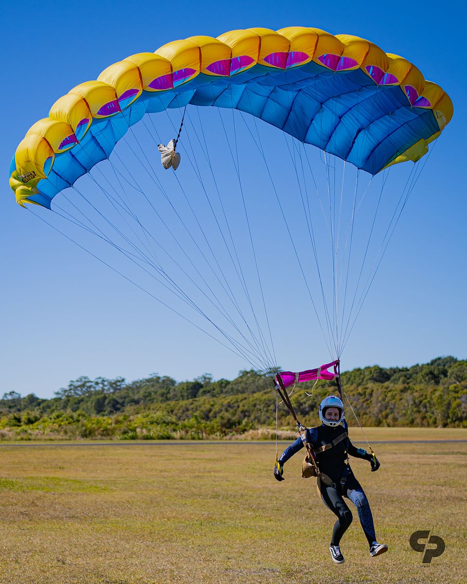 A jumper landing under a bright multicoloured canopy