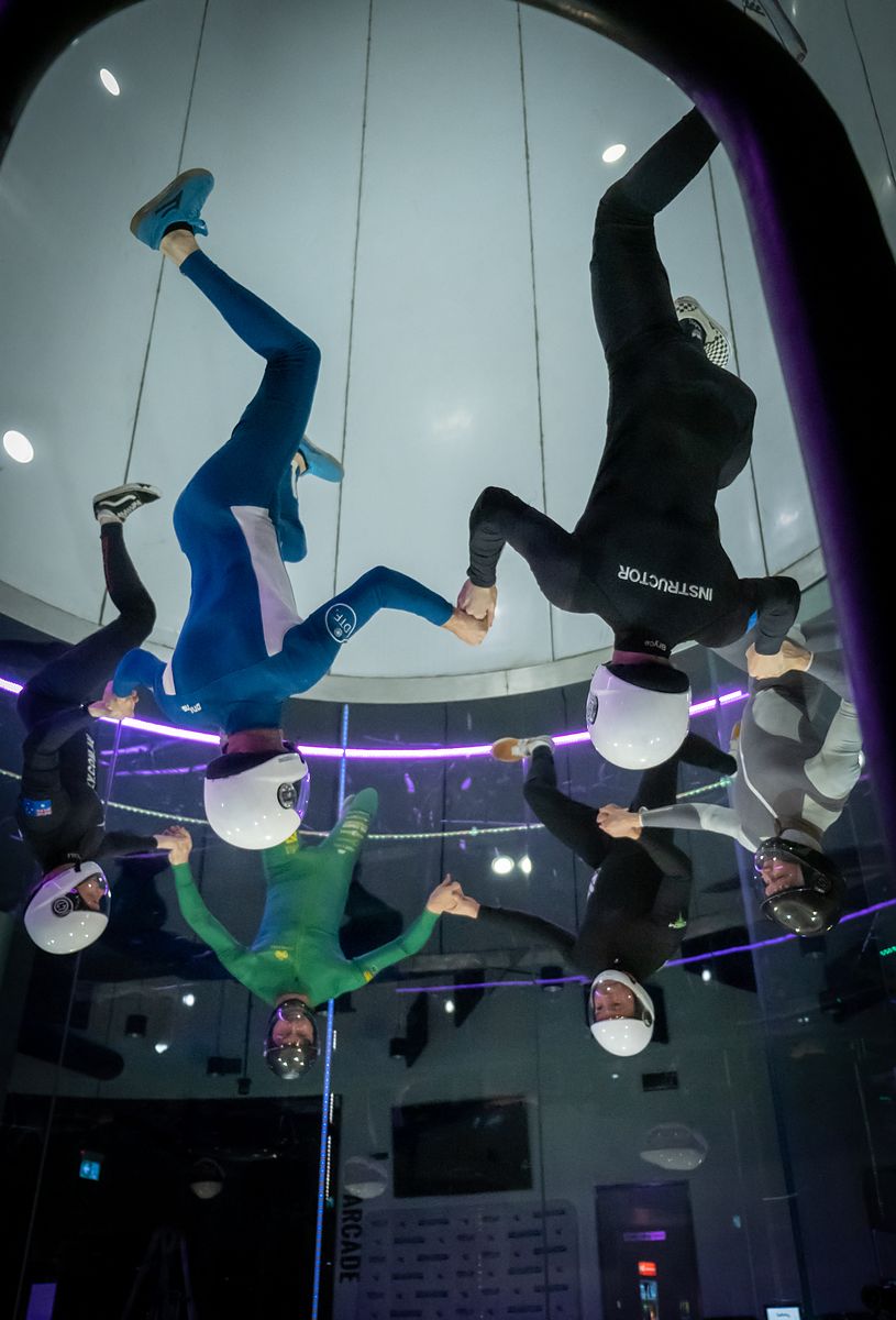Four flyers working the wind tunnel chamber together