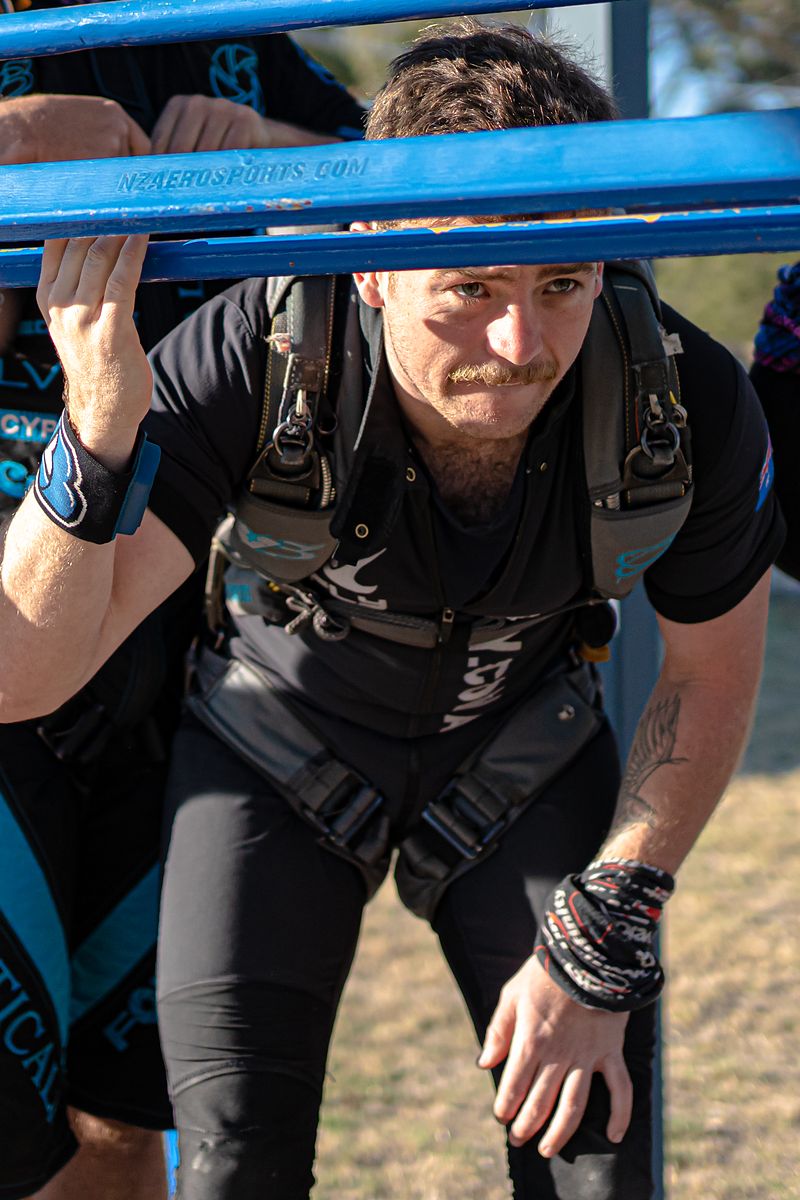 A flyer hanging off the aircraft strut before letting go