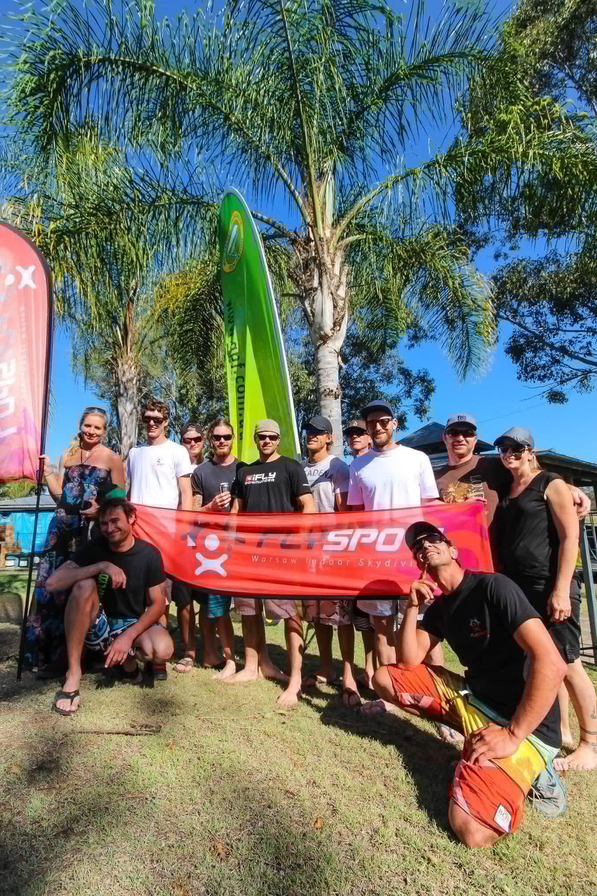 A camp group with their banner under the palm trees